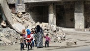 Eine Familie läuft durch die Trümmer der syrischen Stadt Aleppo © picture alliance / abaca Foto: Ammar Abd Rabbo