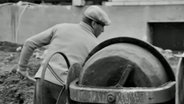 Ein Bauarbeiter hinter einem Betonmischer © ARD 