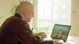 Panorama-Autor Philipp Hennig sitzt an einem Tisch und schaut auf einen Laptop. © NDR Foto: Screenshot