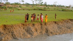 Kinder stehen an der Abbruchkante eines Flusses in Bangladesch.  Foto: Maike Rudolph