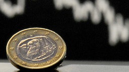 Eine griechische Euro-Münze vor einer fallenden Kurve. © dpa-Bildfunk Foto: Boris Roessler