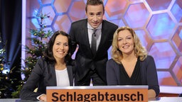 Anne Will, Kai Pflaume und Bettina Tietjen posieren in der Kulisse der Sendung "Dalli Dalli" © NDR Foto: Thorsten Jander