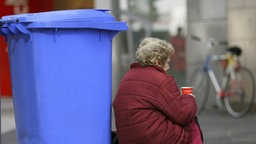 Eine Bettlerin sitzt vor einer Mülltonne auf der Straße © dpa-Report Foto: Uwe Anspach