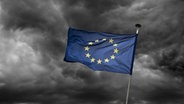 Eine europäische Flagge flattert vor dunklem Wolkenhimmel im Wind. © picture alliance Foto: Klaus Ohlenschläger