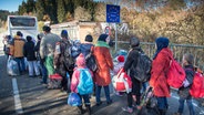 Flüchtlinge laufen von der Notunterkunft nahe der oberösterreichischen Ortschaft Hanging (Österreich) auf die deutsche Seite Richtung Wegscheid (Bayern/Deutschland) zu einem bereitgestellten Bus. © dpa Foto:  Peter Kneffel