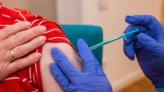 Ein Arzt setzt die Nadel am Oberarm eines Bewohners eines Altenheims an, der gegen eine Infektion mit dem Coronavirus geimpft wird. | Bild: Inderlied/Kirchner-Media © Inderlied/Kirchner-Media 