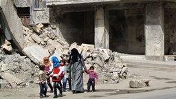Eine Familie läuft durch die Trümmer der syrischen Stadt Aleppo © picture alliance / abaca Foto: Ammar Abd Rabbo