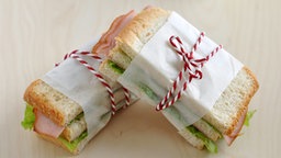 Zwei mit einem Faden zusammengebundene Sandwiches.  © fotolia Foto: A Lein
