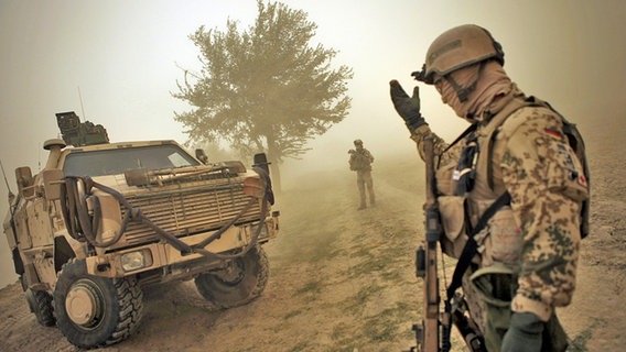 Ein Soldat winkt ein gepanzertes Fahrzeug zu sich heran. © picture alliance / JOKER Foto: Timo Vog