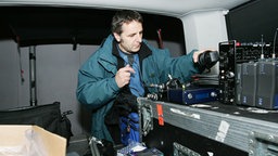 Ein Techniker beim Einpacken von Equipment © NDR Foto: Christian Spielmann