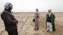 Mariam Noori (mitte) steht mit ihrem Großvater (r.) und einer weiteren Person auf einem Feld © NDR 