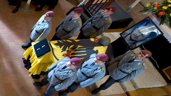 Bundeskanzlerin Merkel vor den Särgen der in Afghanistan getöteten Soldaten.  