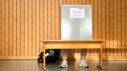 Ein Mann sitzt in einer Sporthalle in
einer Wahlkabine bei der 18. Landtagswahl in Nordrhein-Westfalen. © picture alliance/dpa / Marius Becker 