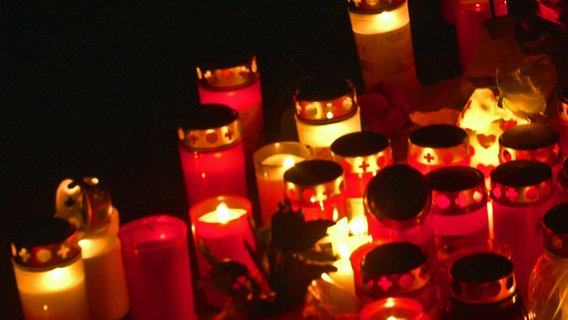 Kerzen stehen am Ort des Brandanschlages auf Delali A.  