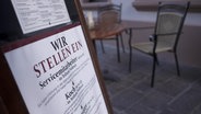 Plakat vor einem gastronomischen Betrieb mit der Aufschrift "Wir stellen ein" © NDR/ARD Foto: Screenshot