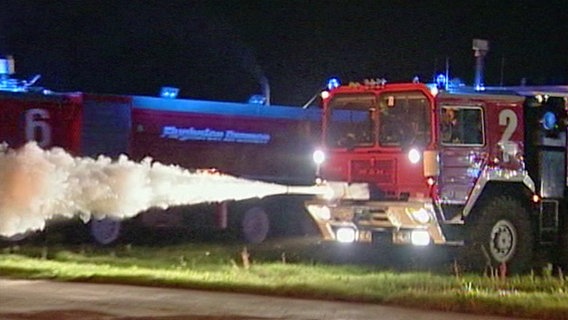 Ein Feuerwehrauto sprüht Löschschaum.  