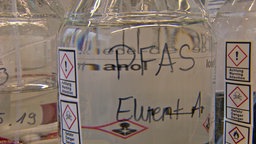 Ein Glasgefäs mit einer Flüssigkeit, die per- und polyfluorierte Alkylsubstanzen (PFAS) enthält. © NDR 