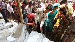 Menschen in Bangladesch suchen nach dem Brand in einer Textilfabrik nach Angehörigen. © dpa-Bildfunk Foto: Abir Abdullah