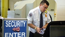 US-Sicherheitsangestellter kontrolliert am Flughafen einen Koffer © dpa - Fotoreport Foto: epa afp Joyce Naltchayan
