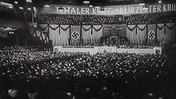 Historische Aufnahme aus dem Nationalsozialismus, Hakenkreuzfahnen und ein Banner mit der Aufschrift "Wollt ihr den totalen Krieg?" © NDR/ARD Foto: Screenshot