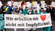 Demonstrierende mit Plakaten gegen eine Impfpflicht © NDR / ARD 