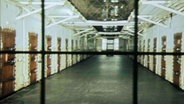 Gefängnistrakt hinter einem Gitter © NDR 