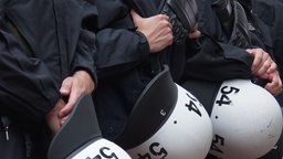 Polizeibeamte mit Helmen in der Hand  
