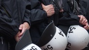 Polizeibeamte mit Helmen in der Hand  