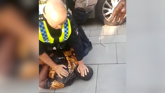 Ein Polizist drückt einen schwarzen Mann zu Boden © NDR Foto: Screenshot