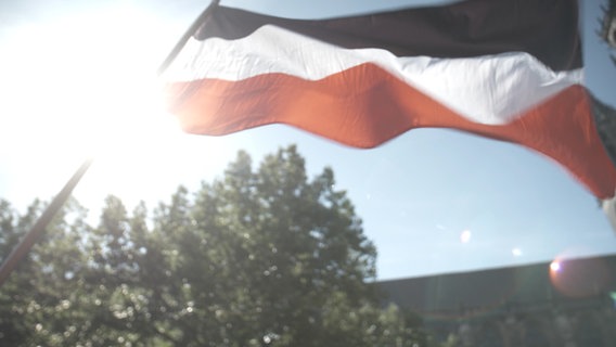 Eine Reichsflagge weht im Wind. © NDR 