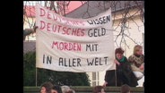 Demonstrierende halten ein Banner mit der Aufschrift "Deutsches Wissen, Deutsches Geld, morden mit in aller Welt" (Archivbild).  
