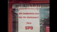 In einem Fenster hängt ein SPD-Plakat mit der Aufschrift "Wir bedanken uns für Ihr Vertrauen" (Archivbild).  