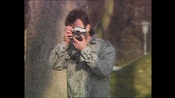 Ein ehemaliger Stasi-IM hält eine Fotokamera (Archivbild).  
