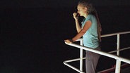 Carola Rackete, Kapitänin der Sea Watch 3, steht an Deck mit einem Funkgerät © NDR Foto: Screenshot