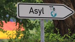 Ein Hinweisschild zur zentralen Anlaufstelle für Asylbewerber in Halberstadt (Sachsen-Anhalt). © dpa Foto: Jens Wolf